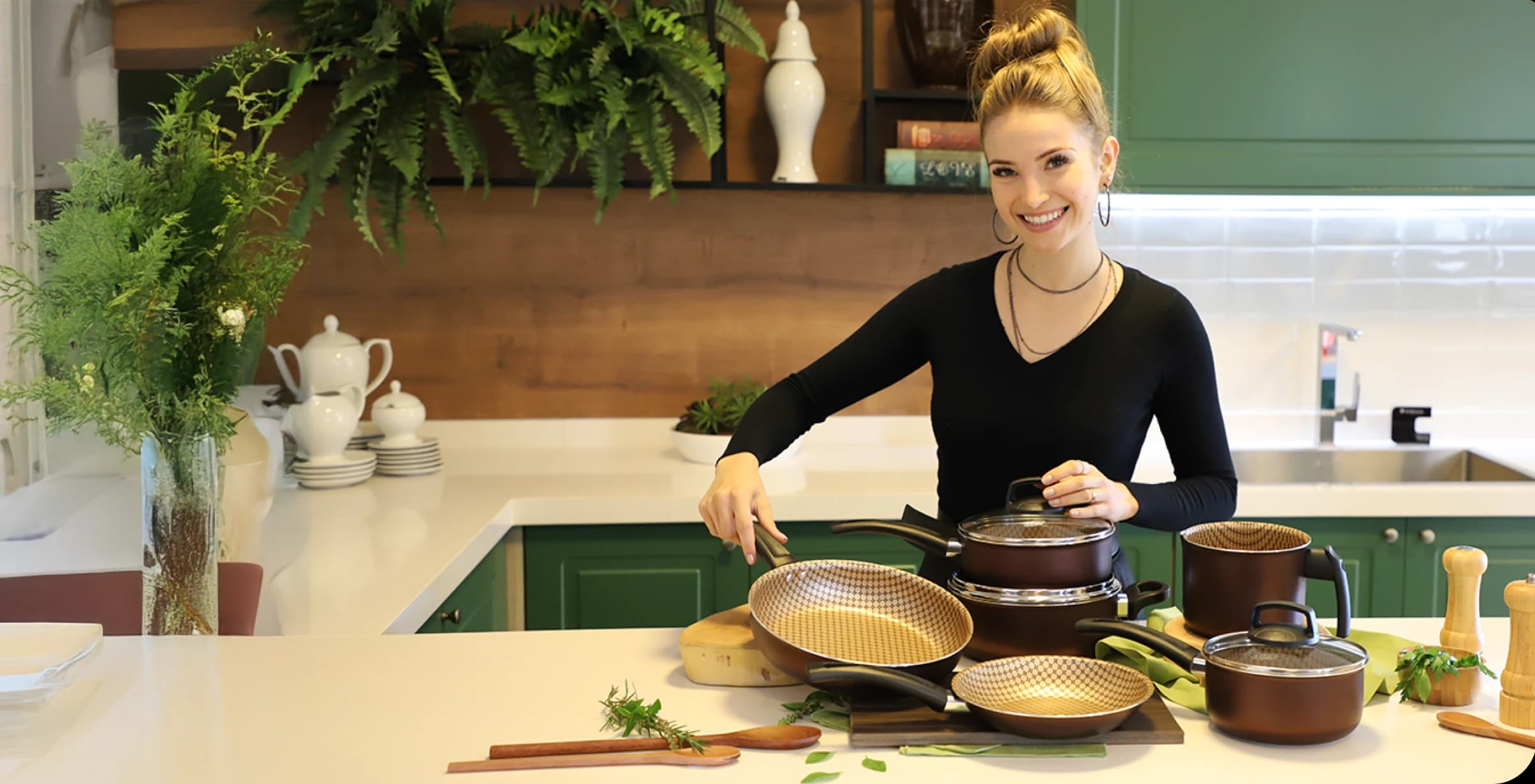 Mulher exibindo o conjunto de panelas da MTA. 
